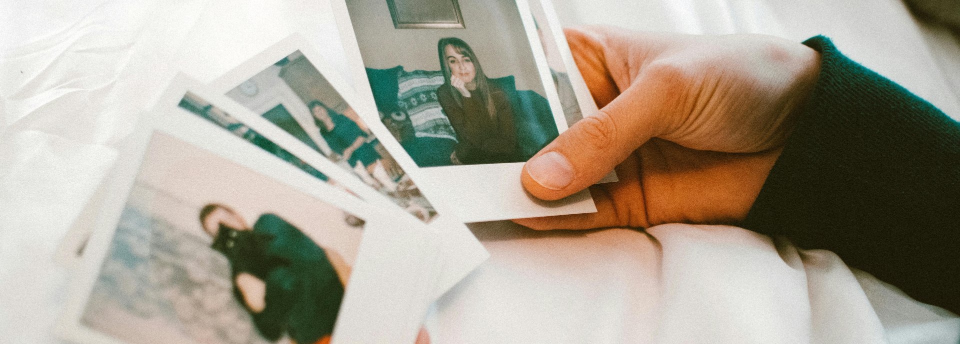 person's hands looking at photos