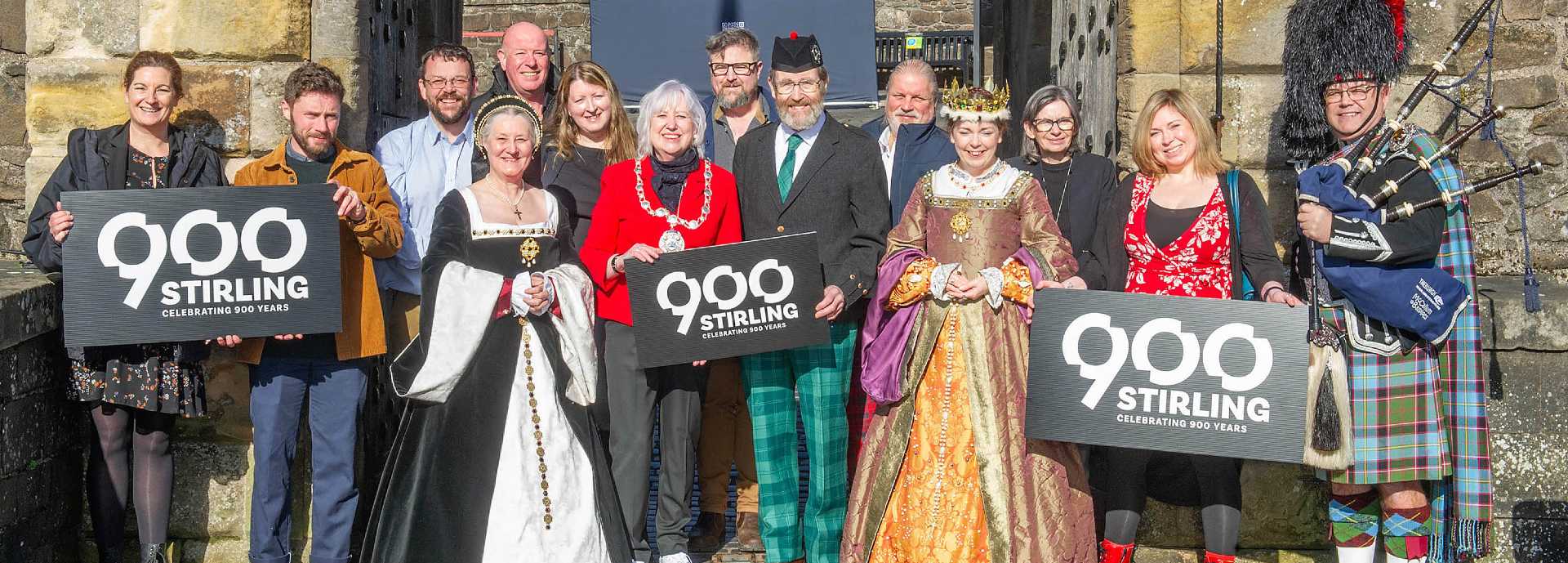 A group photo of representatives from all the partners involved in the Stirling 900n celebrations including Stirling Provost, Elaine Watterson, and the current Earl of Mar; James Erskine and the King’s Hereditary Keeper of Stirling Castle; outside the Stirling Castle gates.