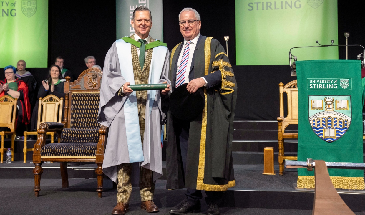 Stanley Morrice poses on stage with Chancellor of the University, The Rt Hon Lord Jack McConnell