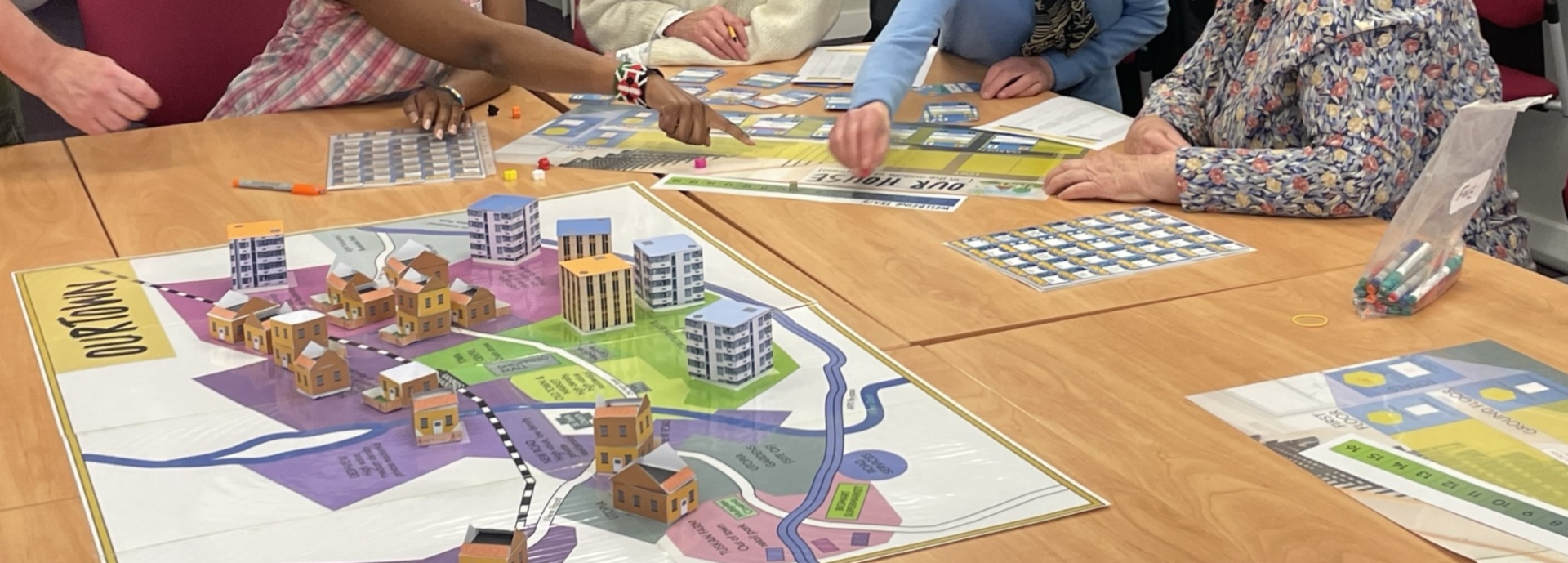 hands playing board game at table