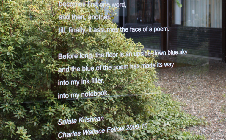 Poem written on glass with leaves in the background
